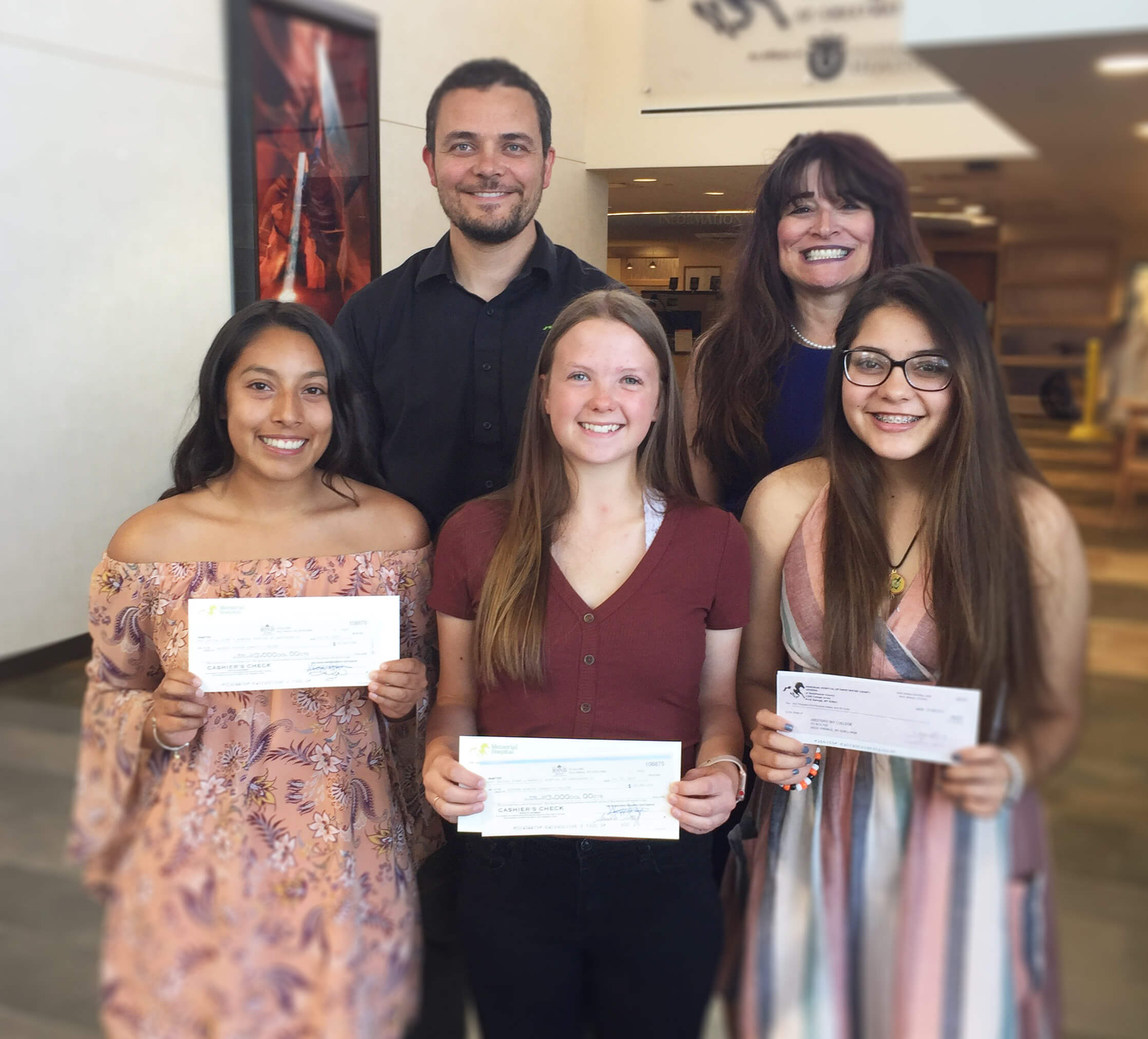 2 adults, 3 students holding awards